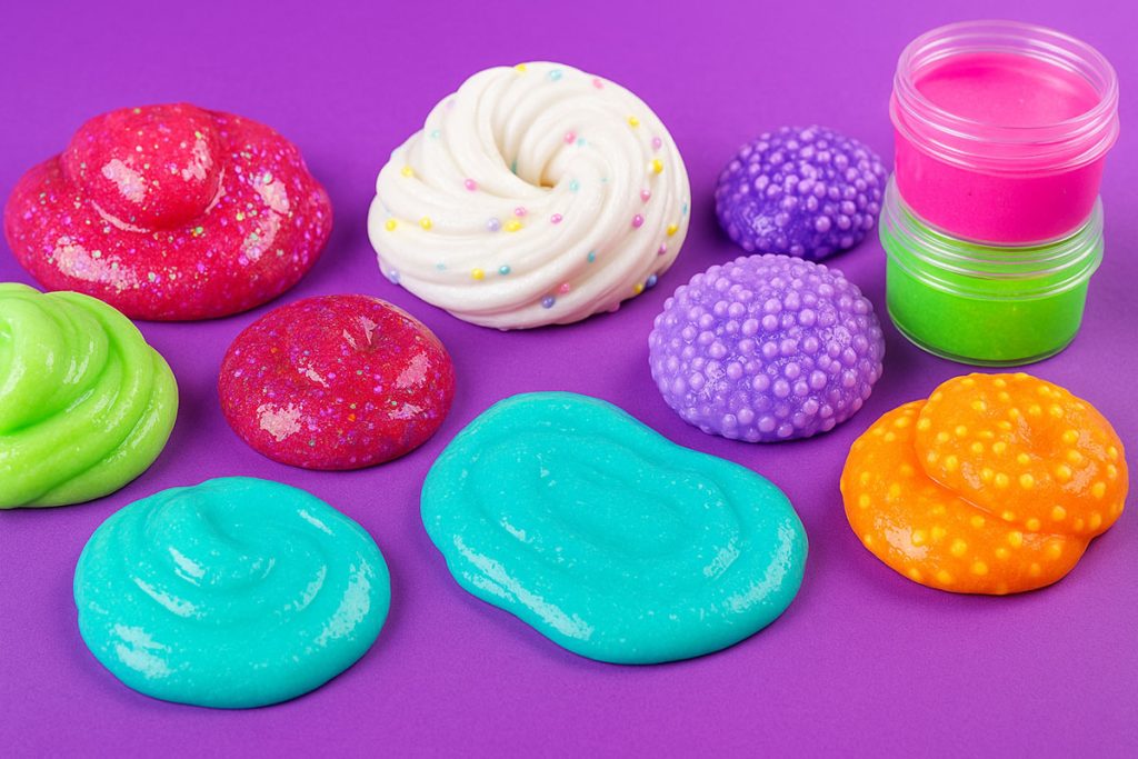 Slime-uri colorate pe fundal mov